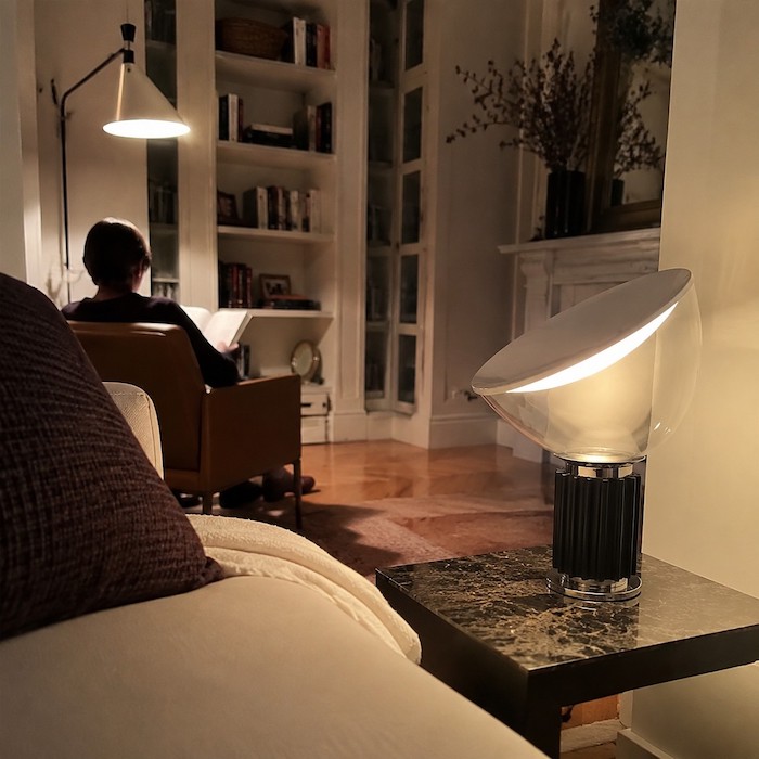 Seated sofa view with a glass lamp placed outside the television reflection path
