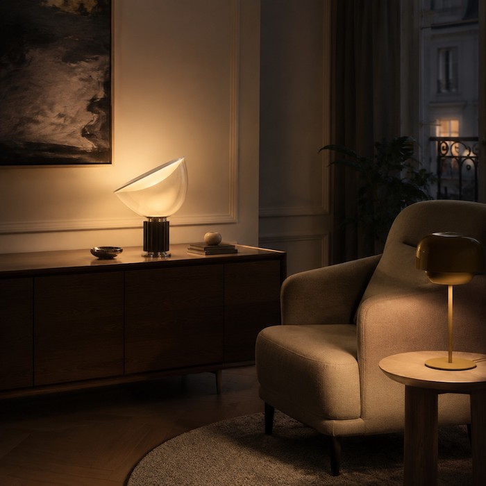 Tilted clear glass bowl table lamp with circular reflector and fluted base on a travertine console
