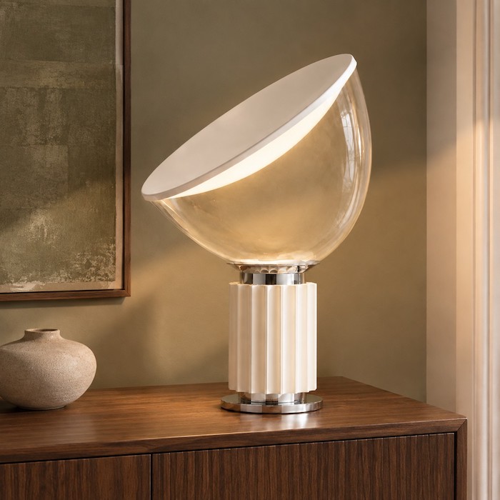 Clear glass lamp made more visible against a muted green and walnut background