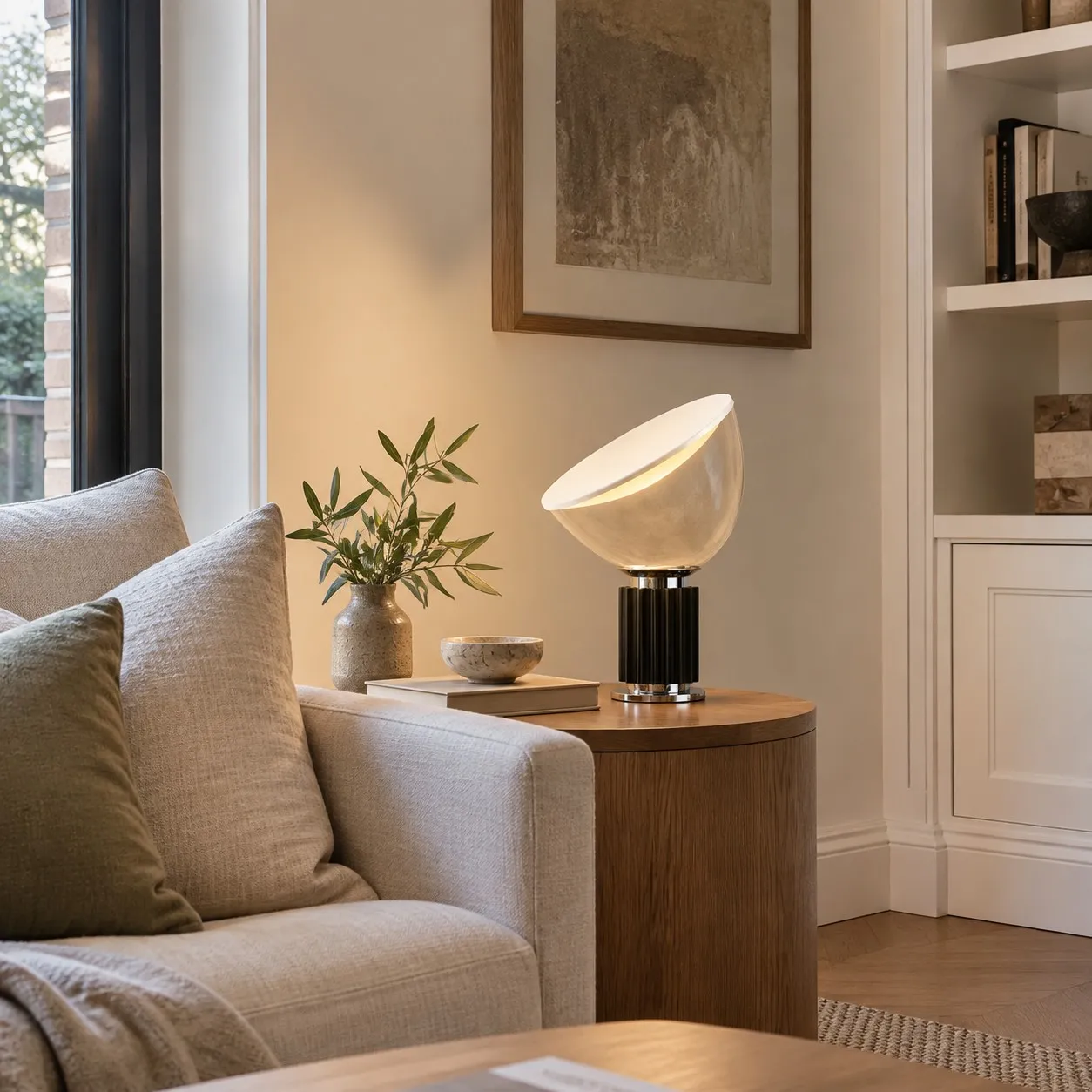 Bowl-shaped glass table lamp casting soft reflected light onto a pale wall.