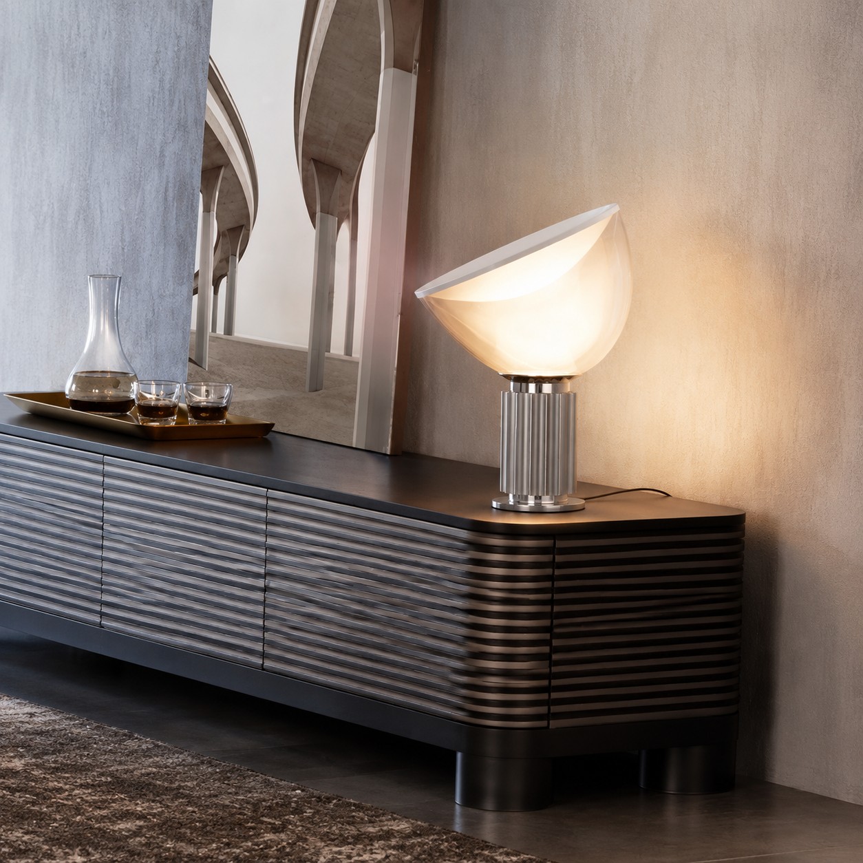 Silver Taccia lamp glowing on a sideboard