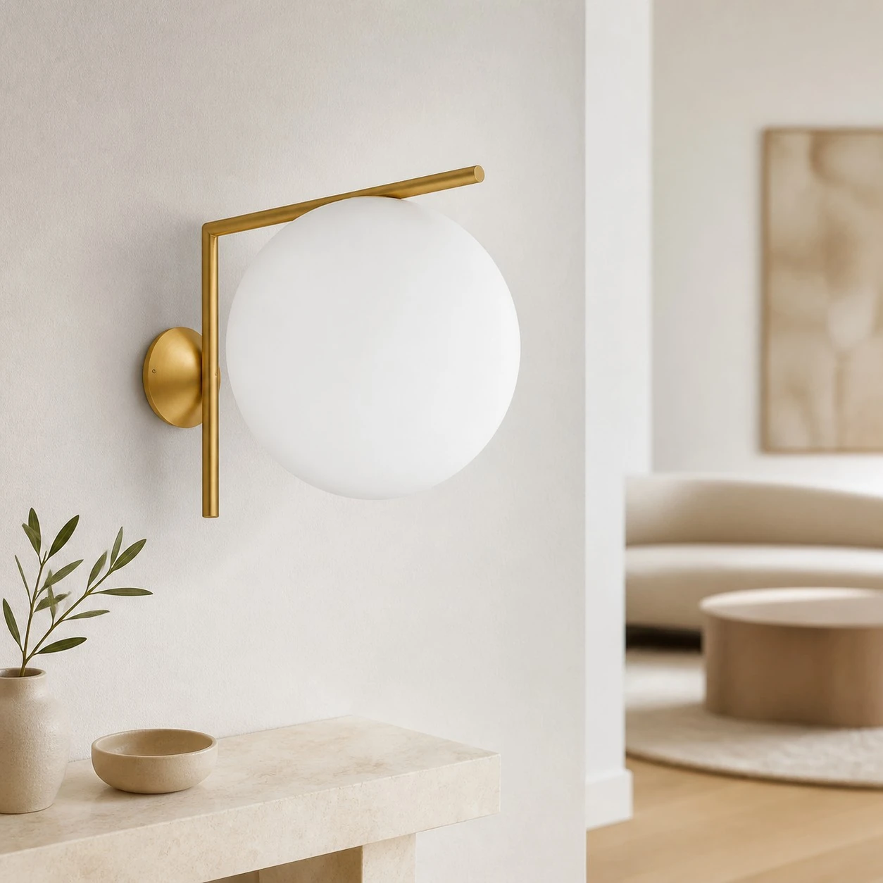 Gold offset globe wall sconce in a bright entryway