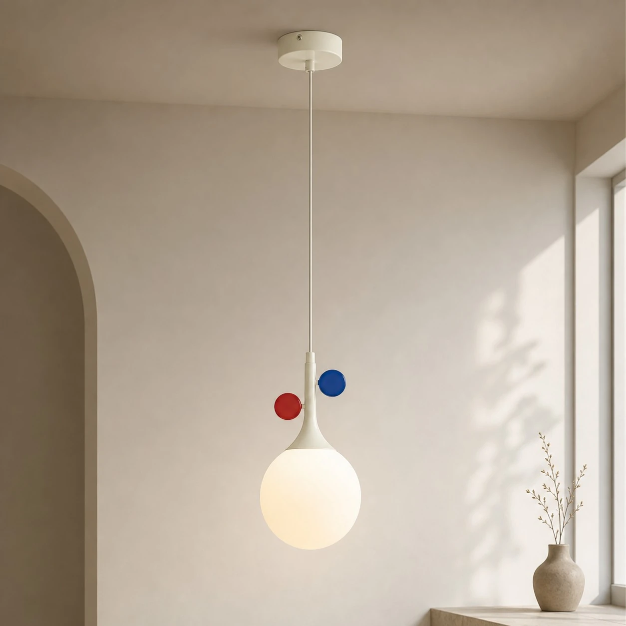 Cream orbit-disc pendant beside a sunlit window