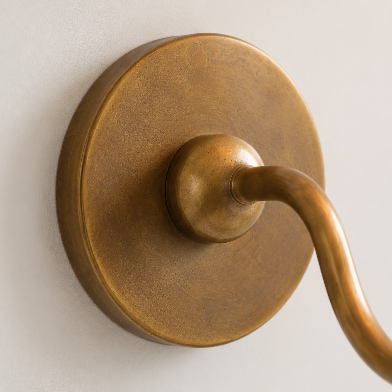 Tumbled brass single-arm wall plate close-up