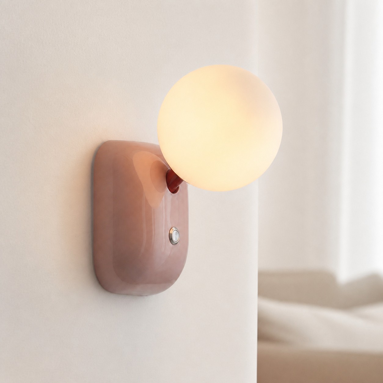 Luma Pink compact globe wall sconce in a soft bedroom