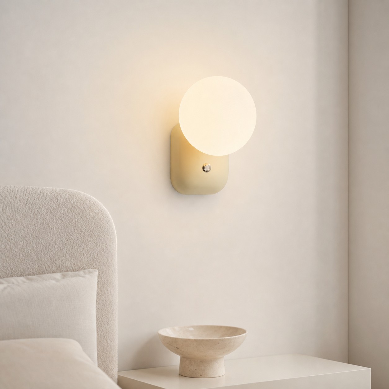Luma Cream White compact globe wall sconce in a calm bedroom