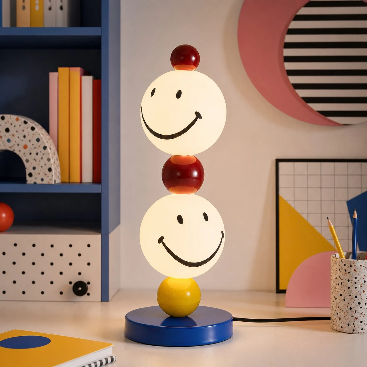 Smiley stack table lamp beside a colorful shelf