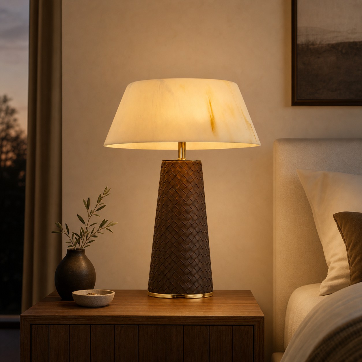 Woven leather table lamp glowing on a bedroom nightstand