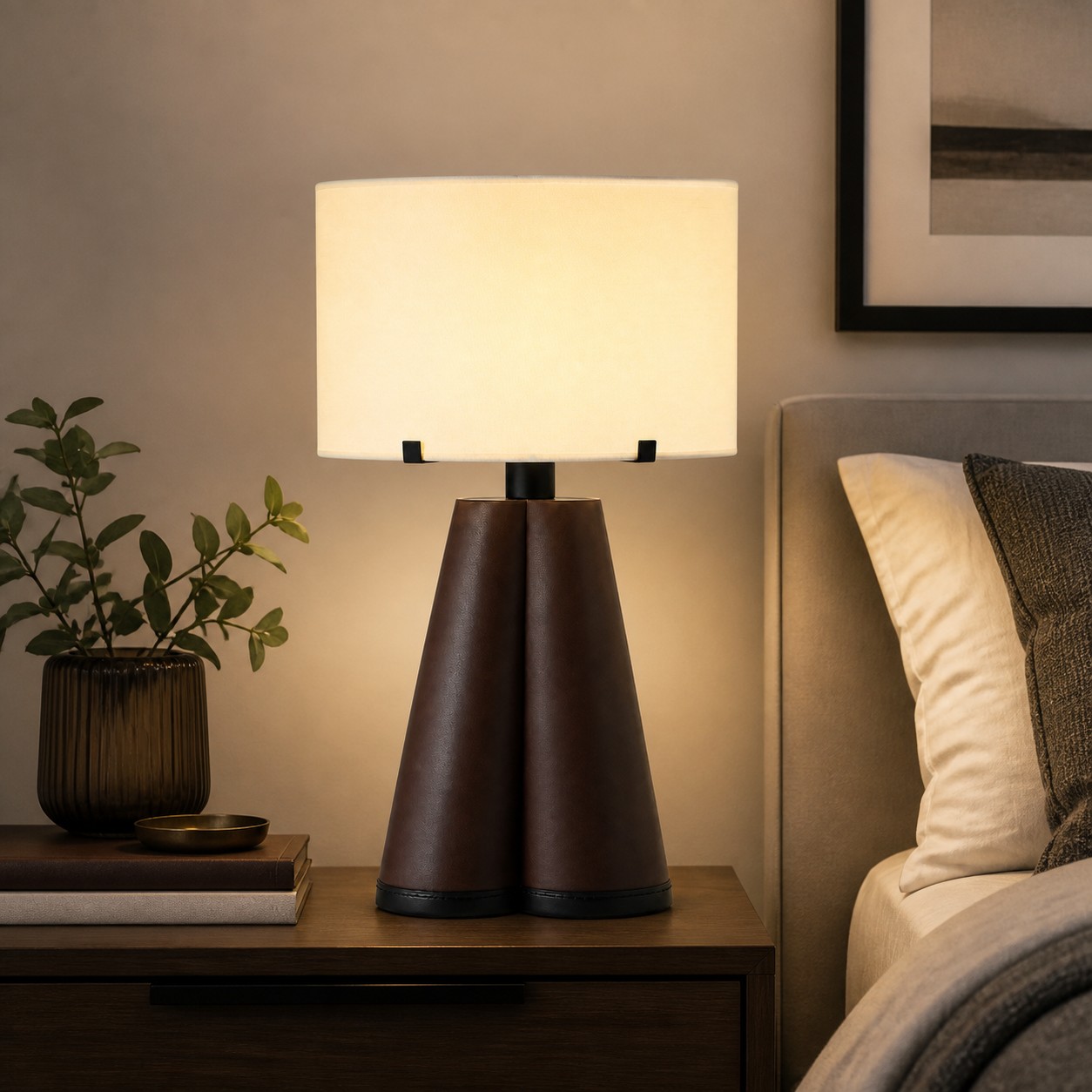 Brown leather table lamp glowing beside a bed