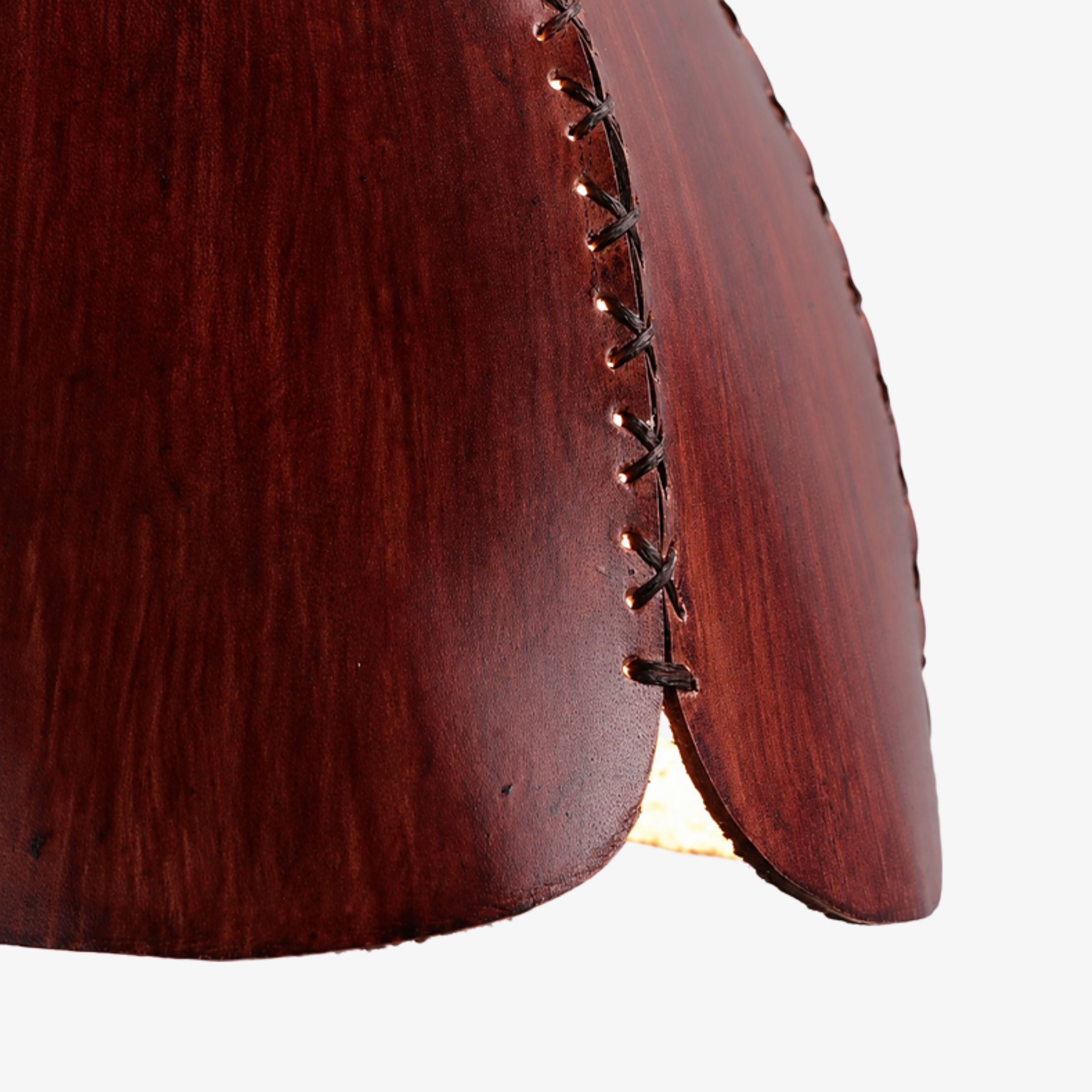 Close-up of hand stitching along the brown leather petals