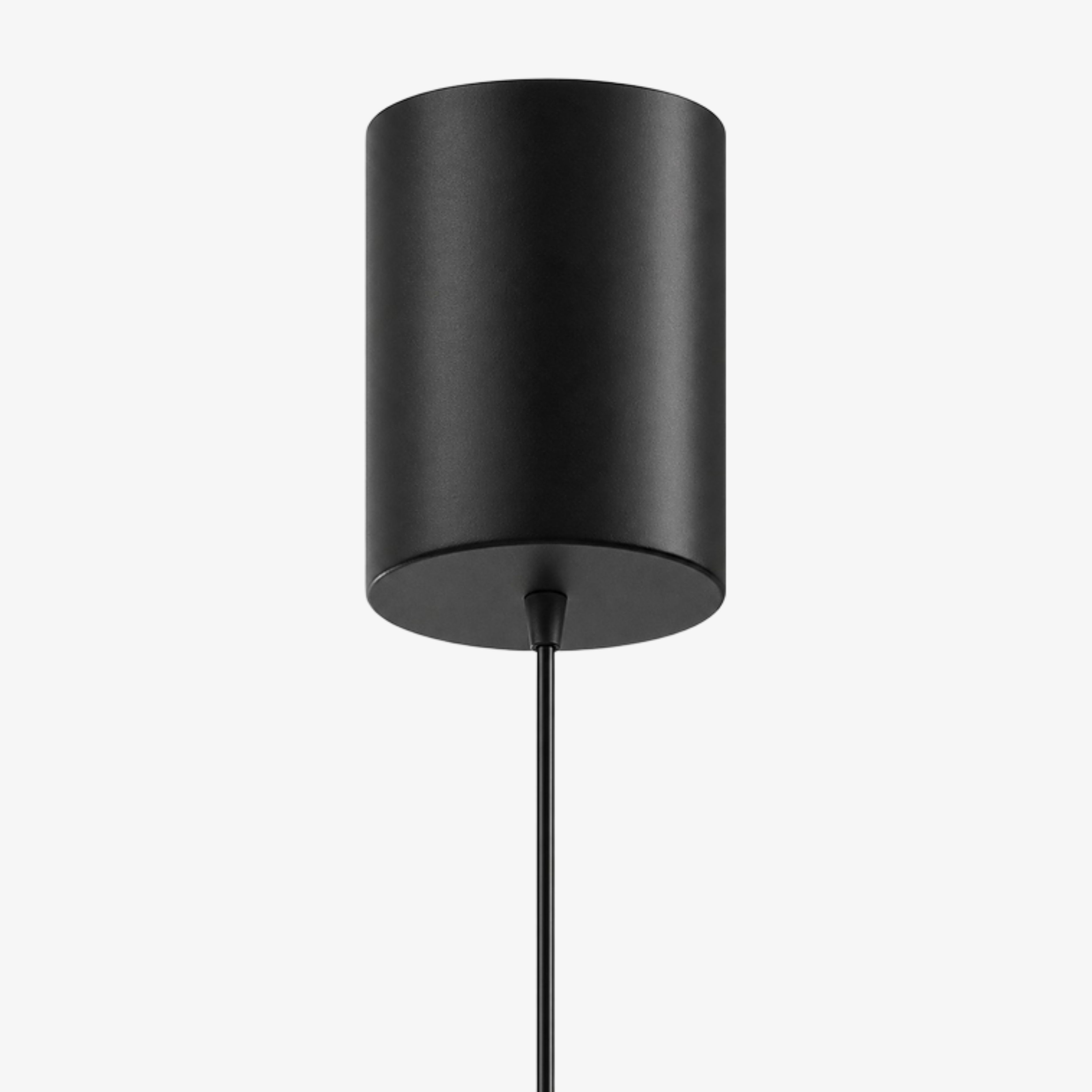 Close view of the cylindrical black ceiling canopy and suspension cable