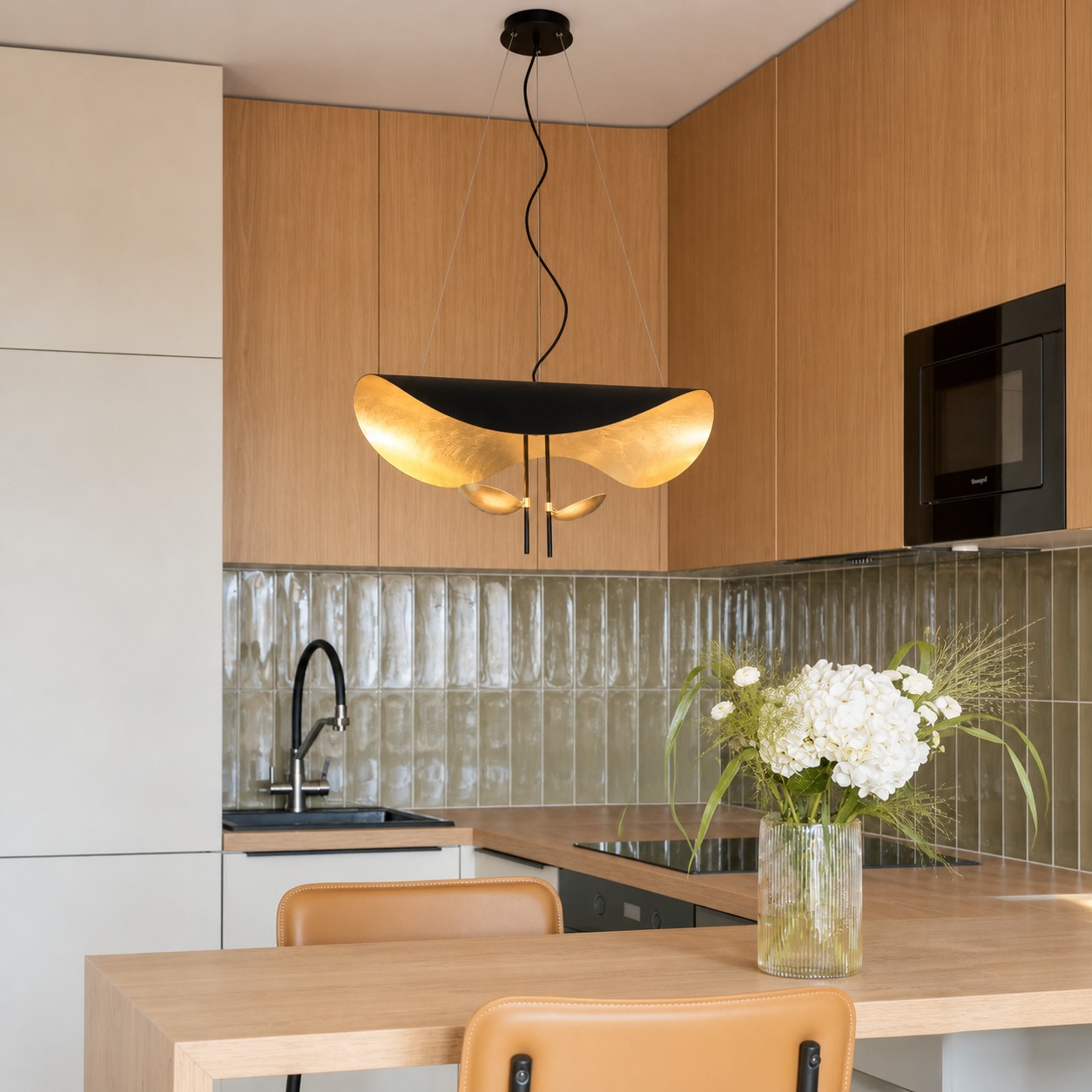 Black and gold sculptural pendant above a kitchen counter