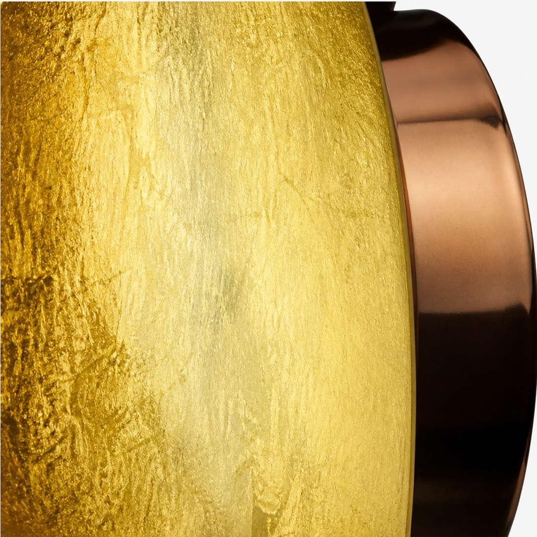 Close-up of the gold-leaf surface and copper-colored disc edge