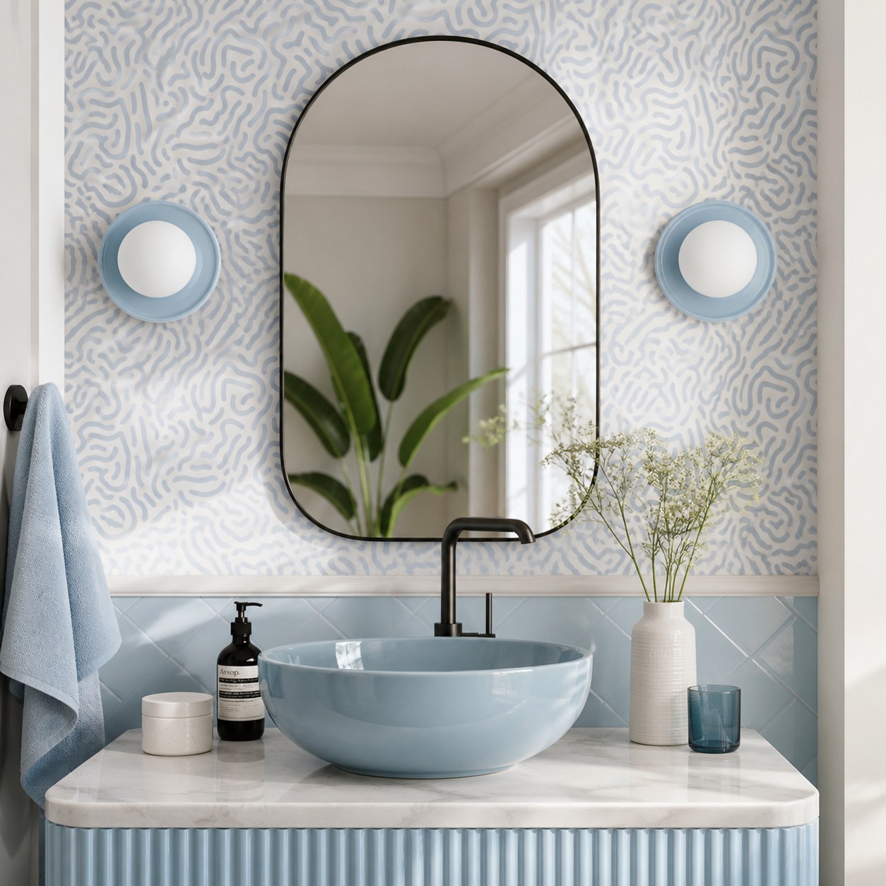 Pair of blue Solna wall lights beside an arched bathroom mirror
