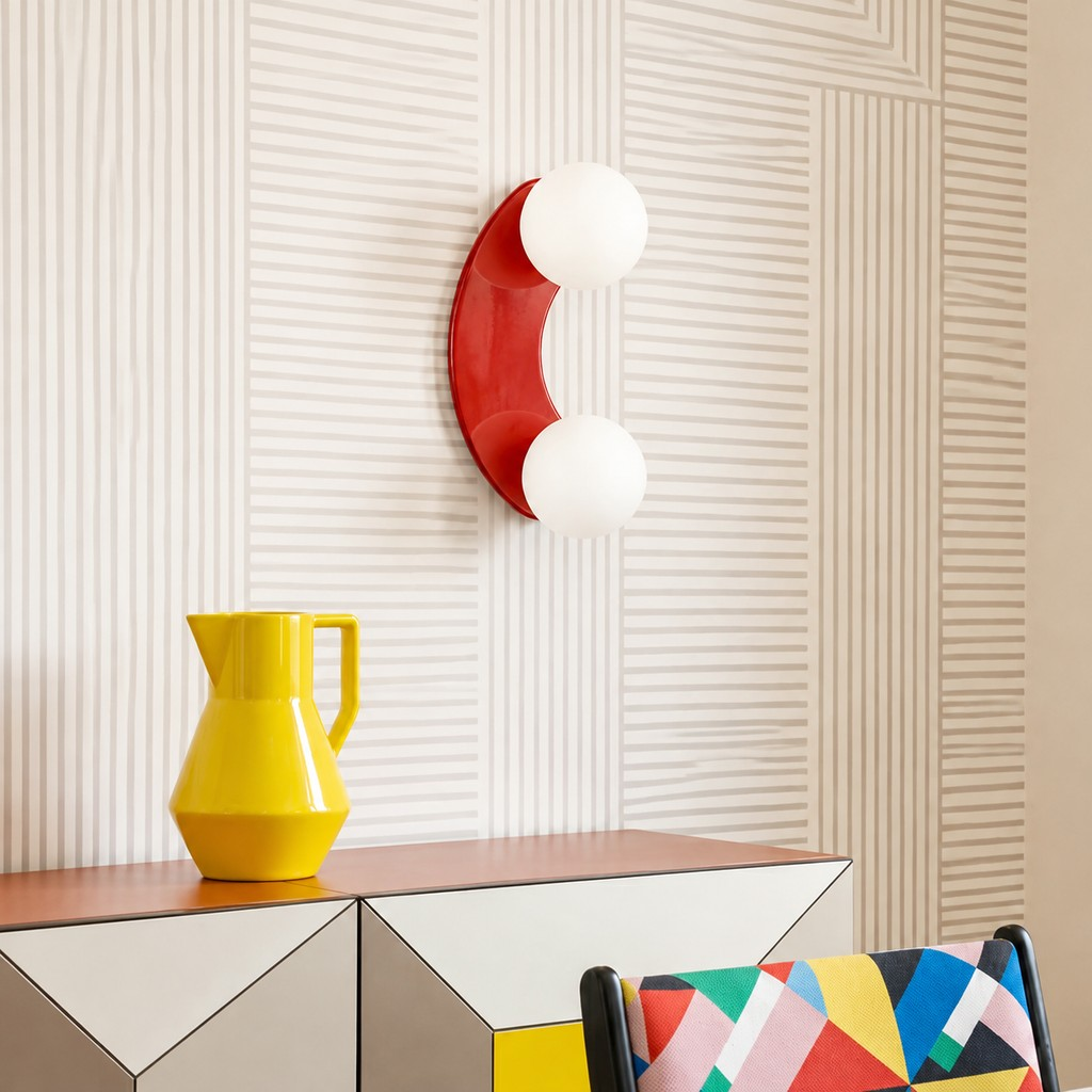 Terracotta double-globe wall lamp beside a coral console