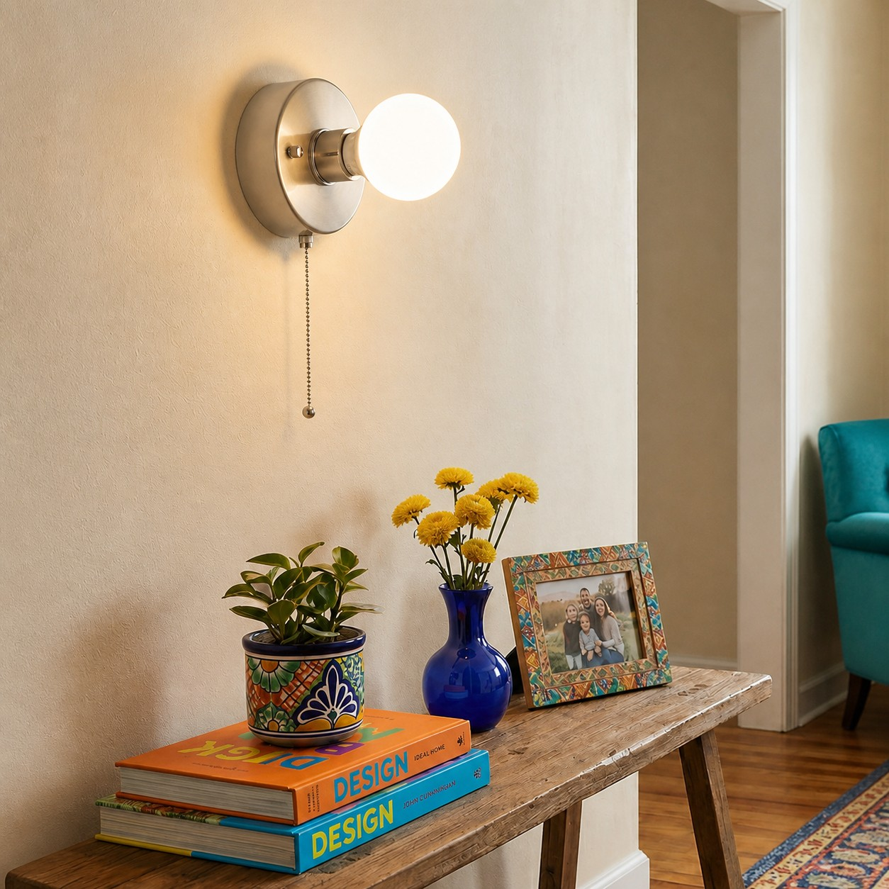 Brushed silver pull-chain wall lamp above a hallway console