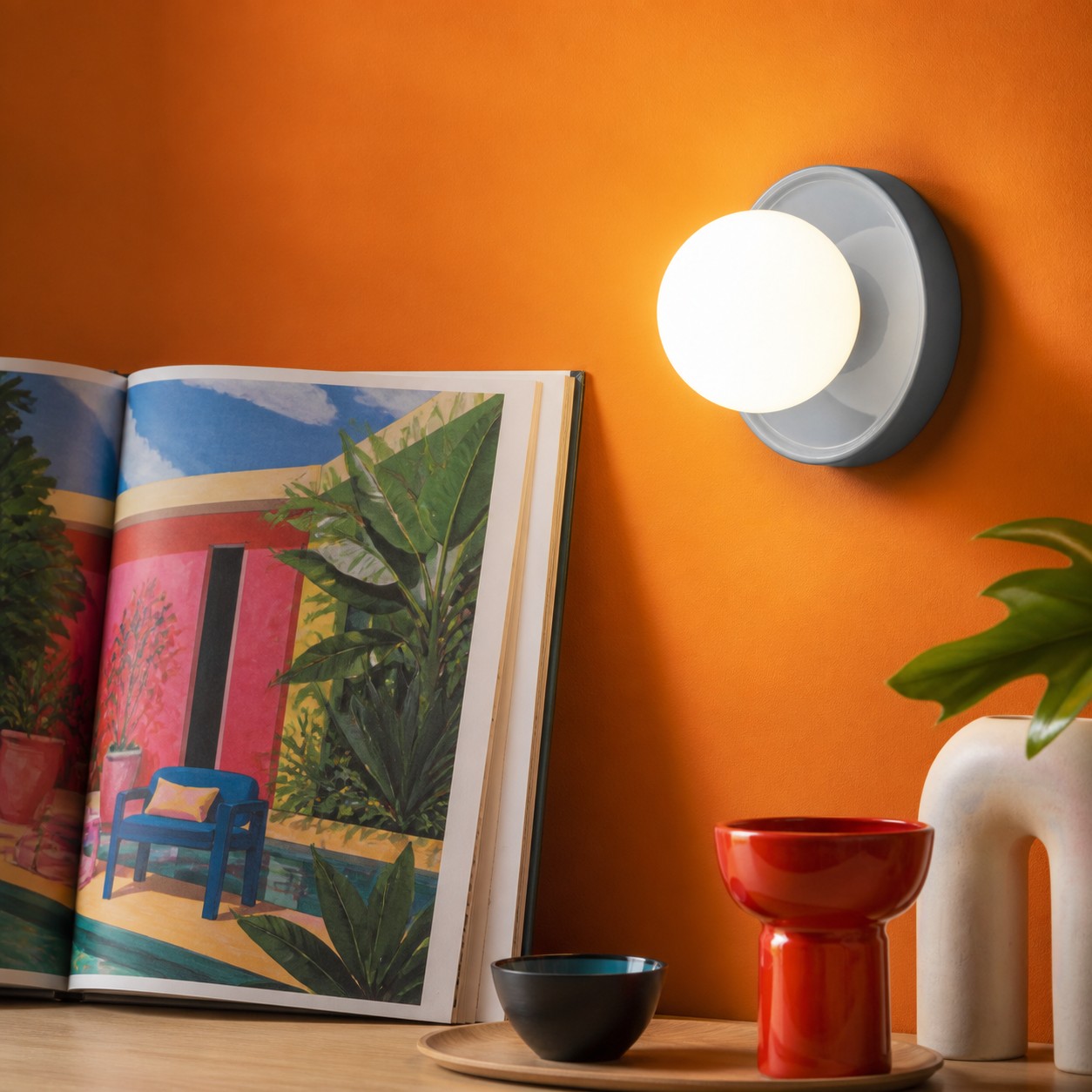 Blue Solna wall light on an orange gallery wall