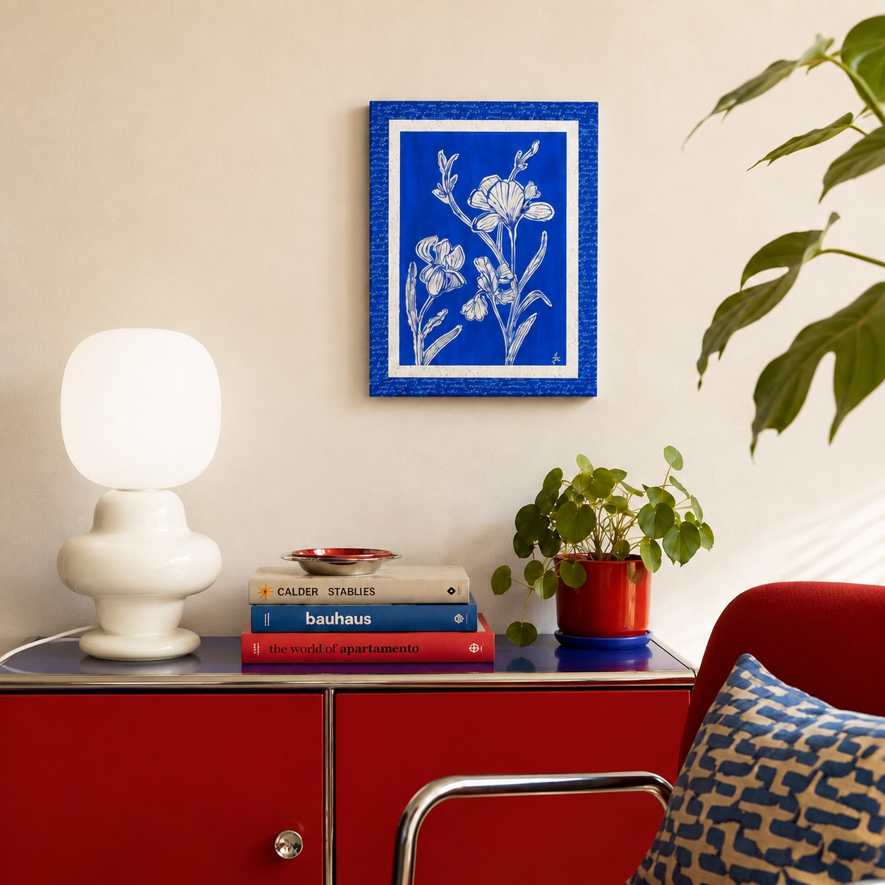 Cream sculptural globe table lamp on a red cabinet
