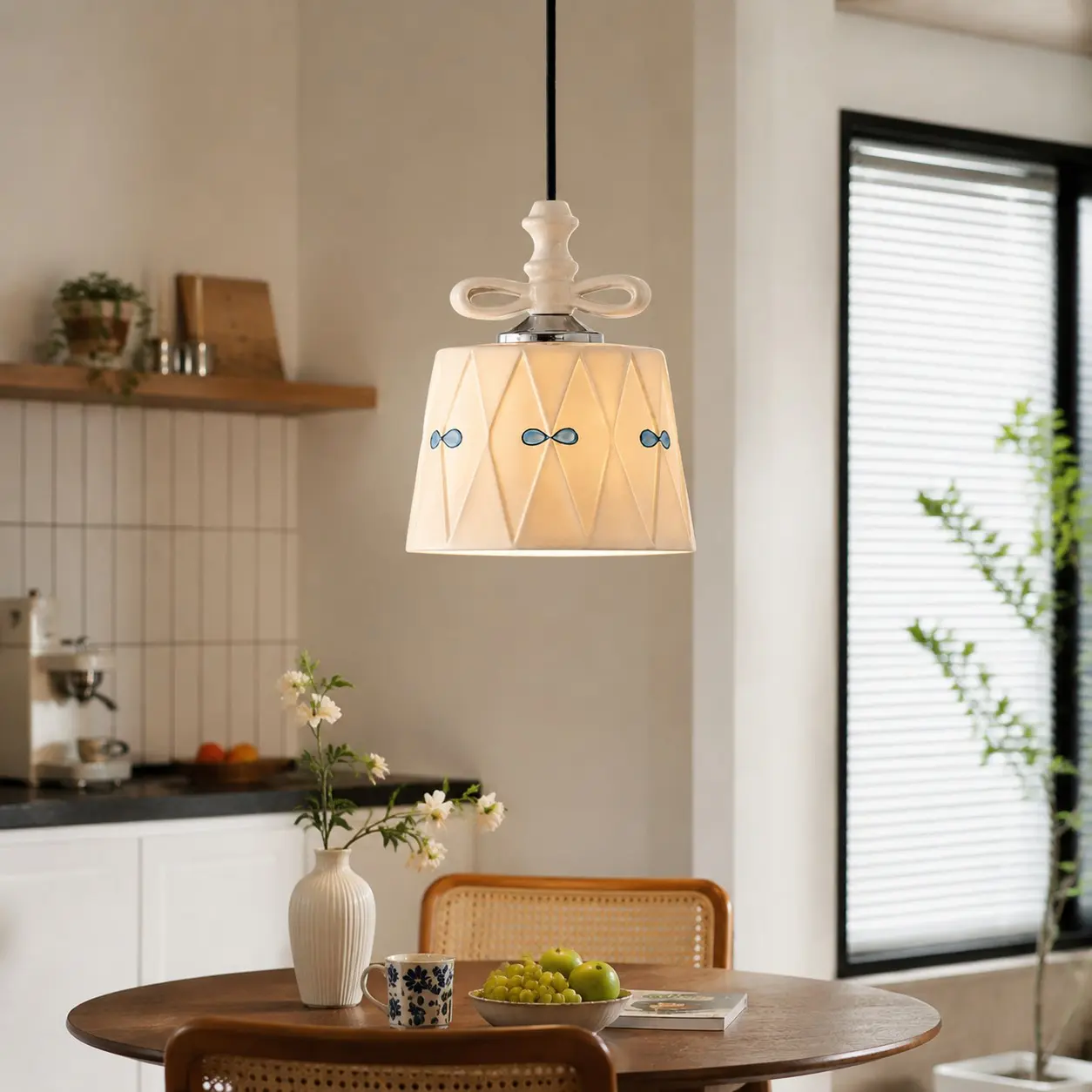 Ceramic bow pendant light above a bright dining table