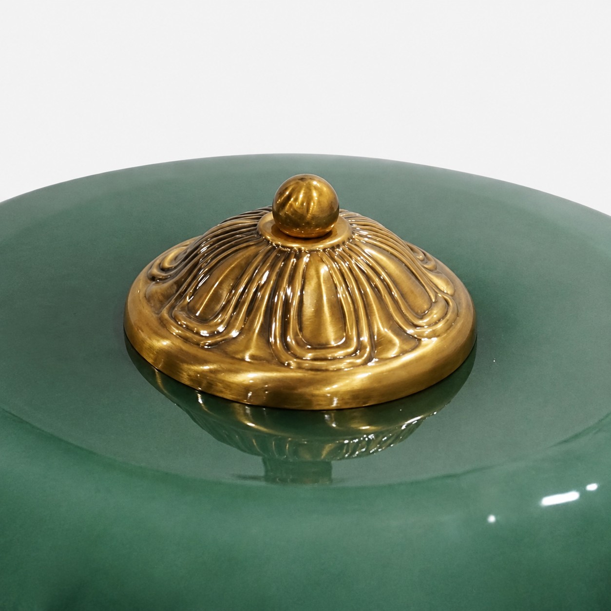 Ornamental brass finial on green glass
