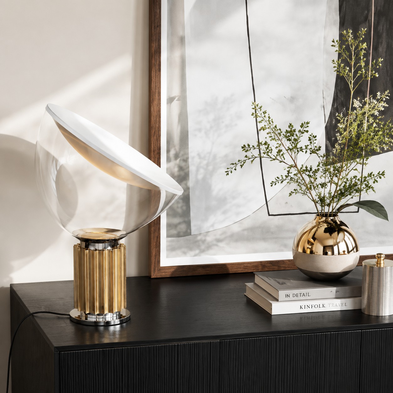 Brushed brass Taccia lamp on a dark console table