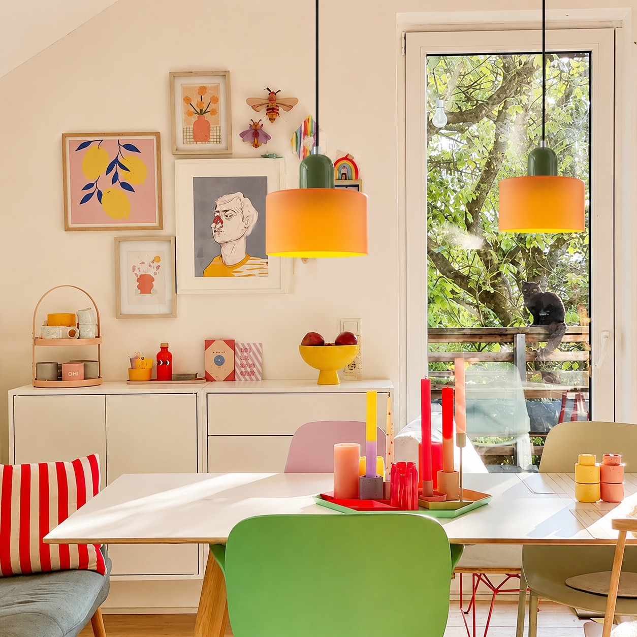 Orange and green Bauhaus glass pendant lights above a colorful dining table