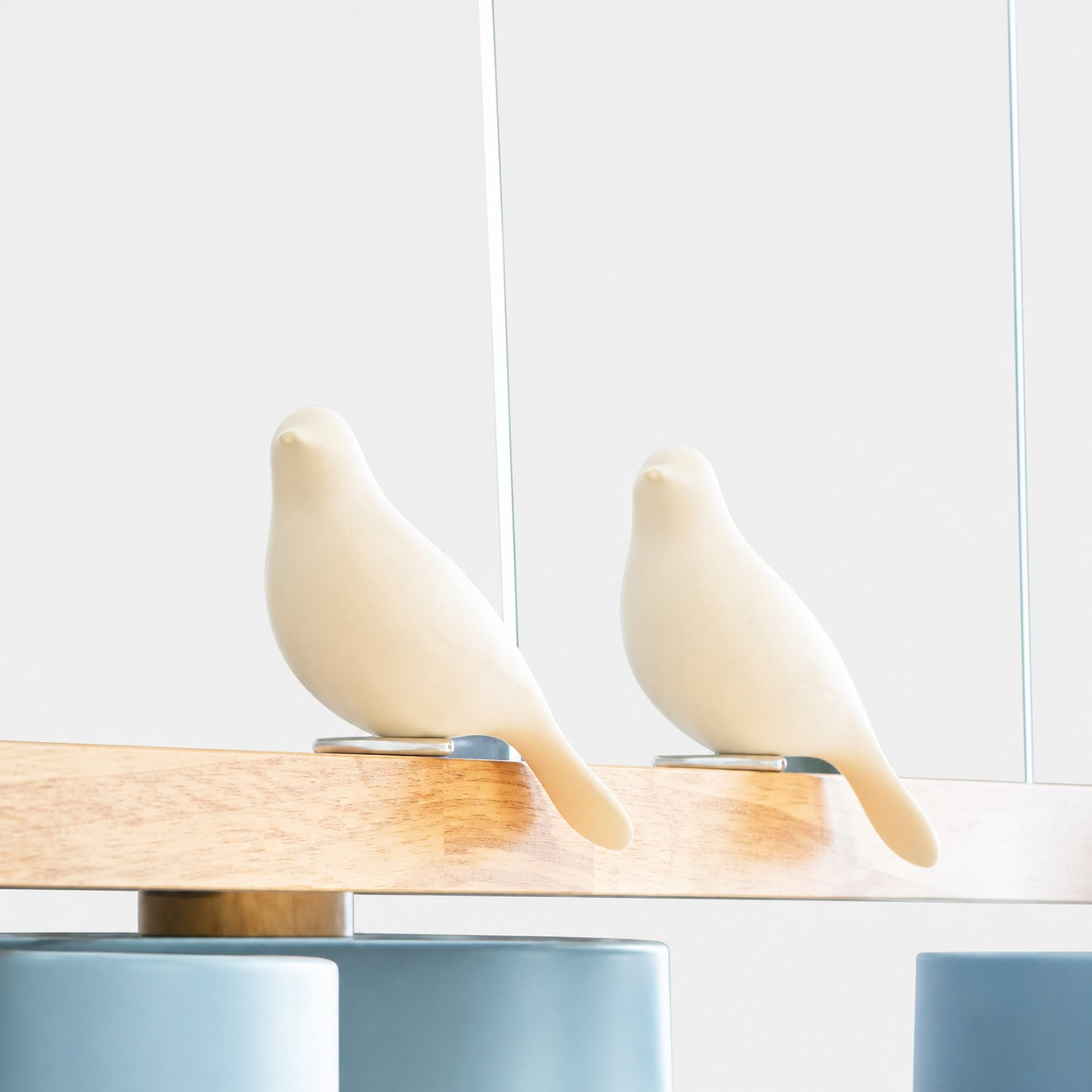 Two resin bird figures perched on the wooden frame