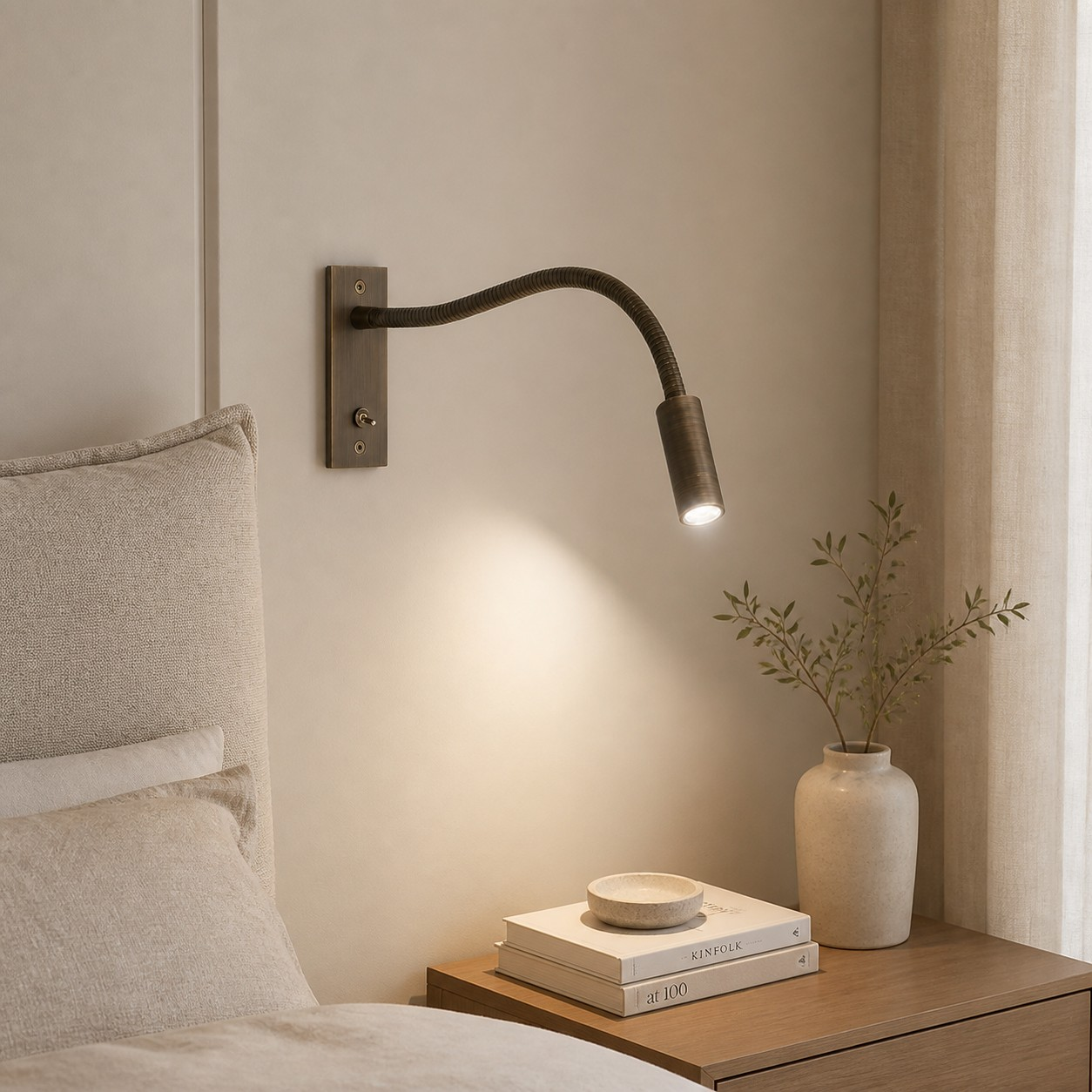 Flexible Schwanenhals-Wandleuchte in gebürsteter Bronze neben einem Bett