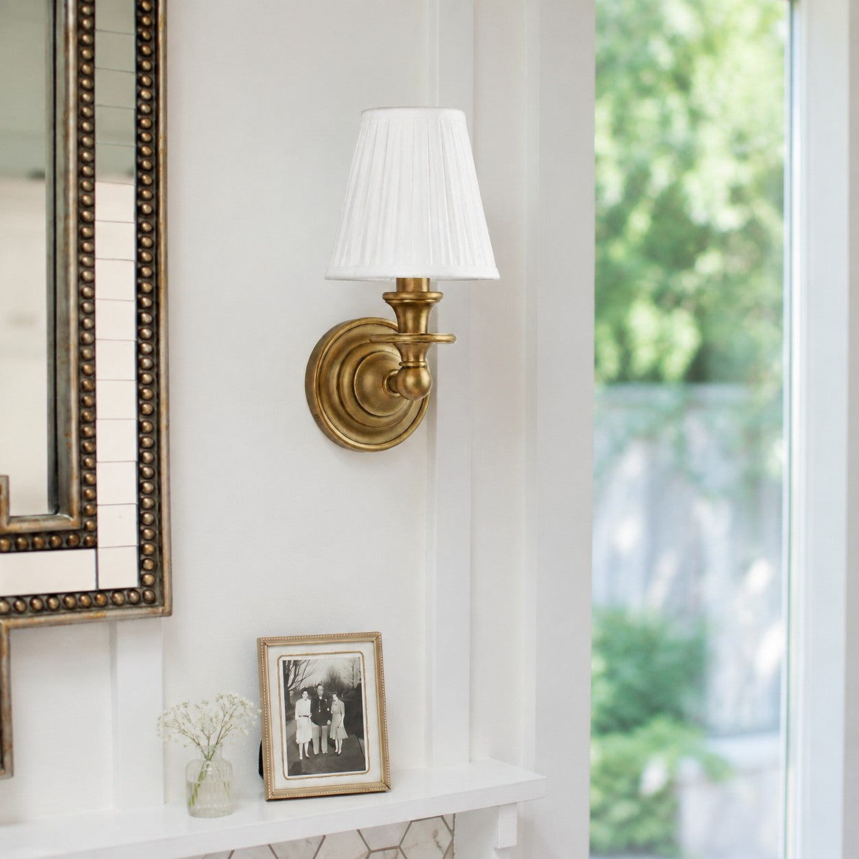 Brass Kalvora wall sconce above a white mantel