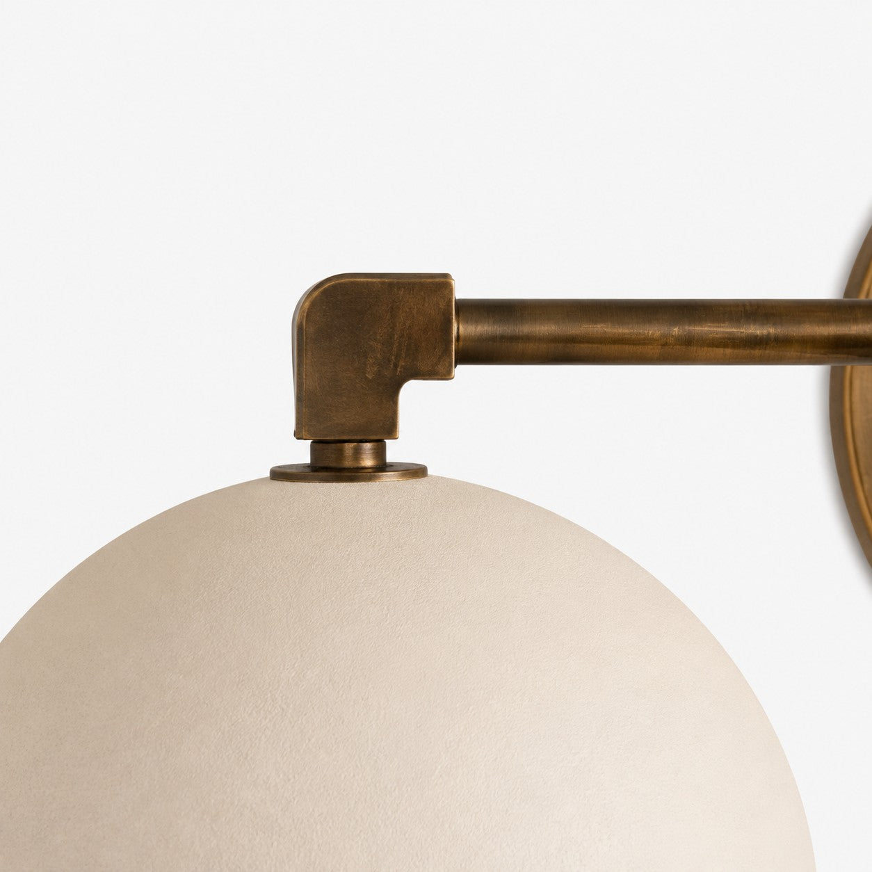 Metio brass elbow joint on a white dome shade