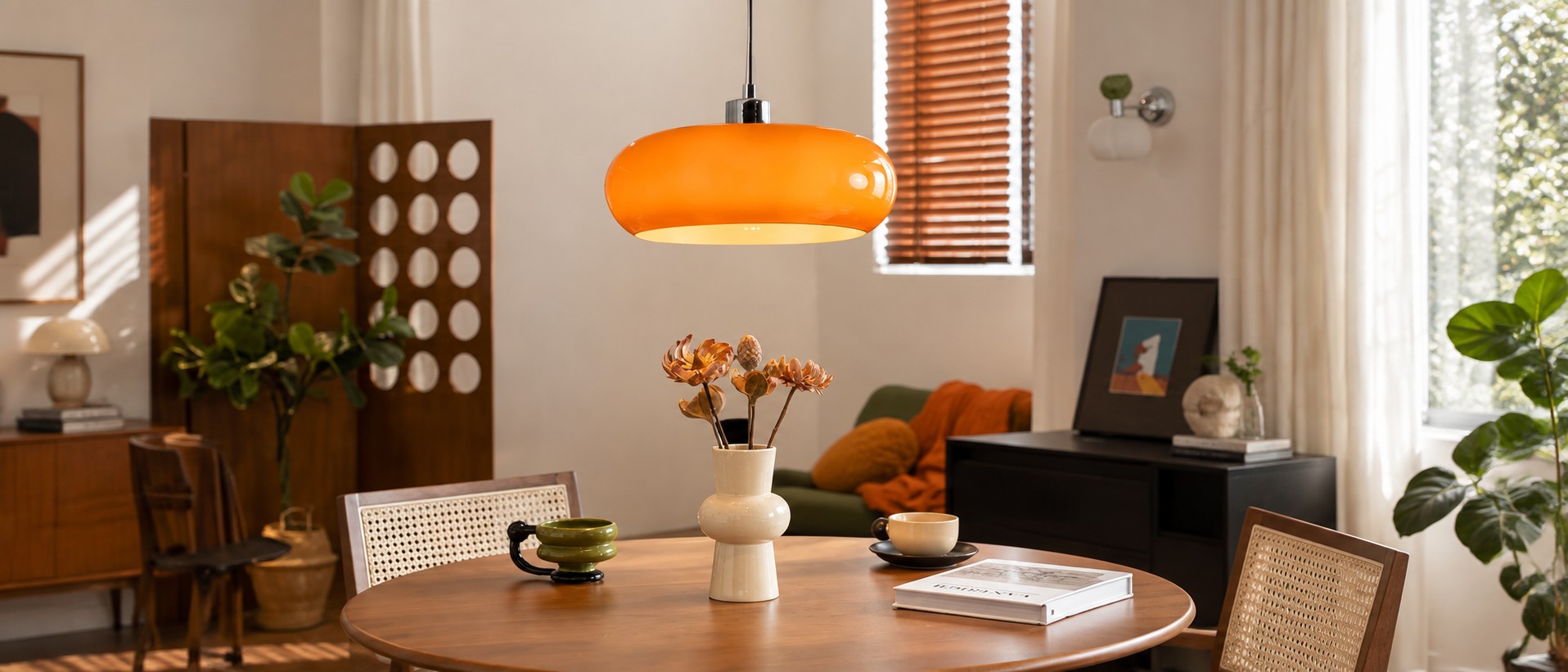 Orangefarbene Glas-Pendelleuchte über einem runden Holzesstisch