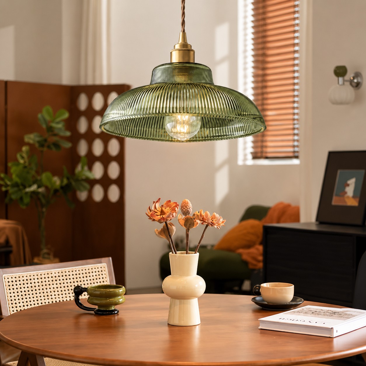 Green pendant light above a dining table