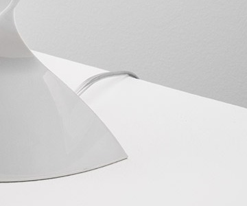 Close-up of the plug-in cord leaving the white base