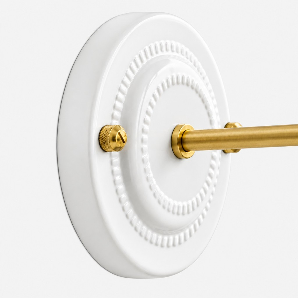 White ceramic backplate with raised beads and brass arm