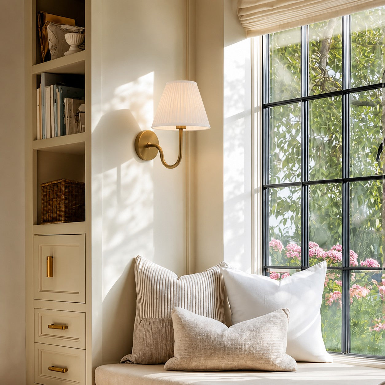Luvora-Wandleuchte mit einem Lampenkopf mit weißem plissiertem Schirm an einem Fensterplatz