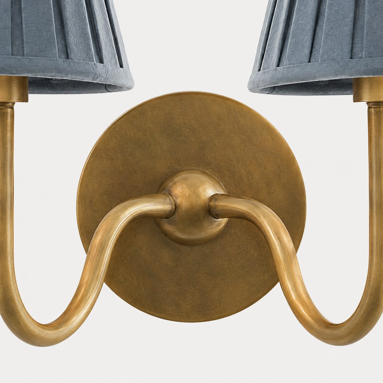 Detail der Messing-Wandplatte und gebogenen Arme der Luvora-Wandleuchte