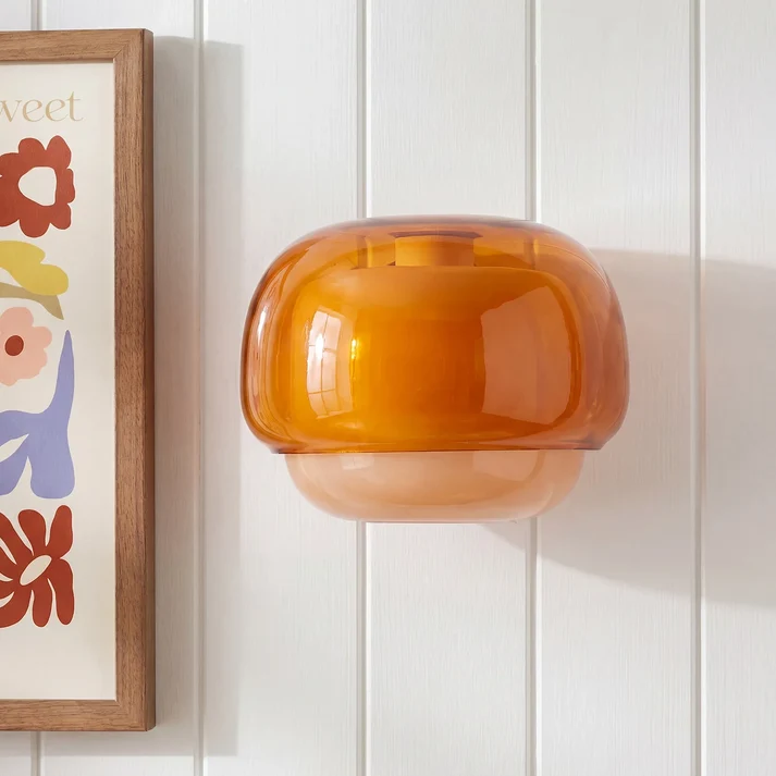 Orvenis orange wall light on a paneled wall