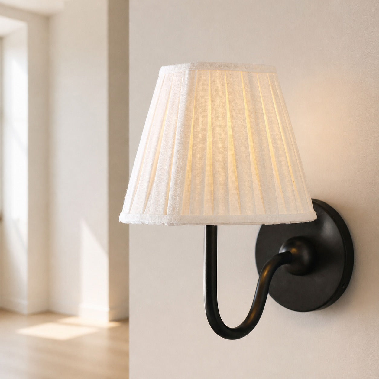 Matte black white pleated 1-Light Luvora wall lamp in a hallway