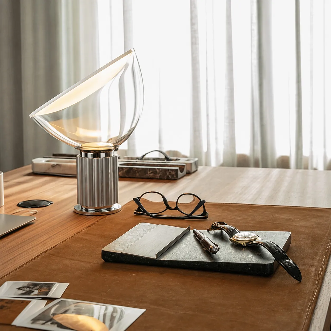 Silver Taccia lamp on a leather writing desk