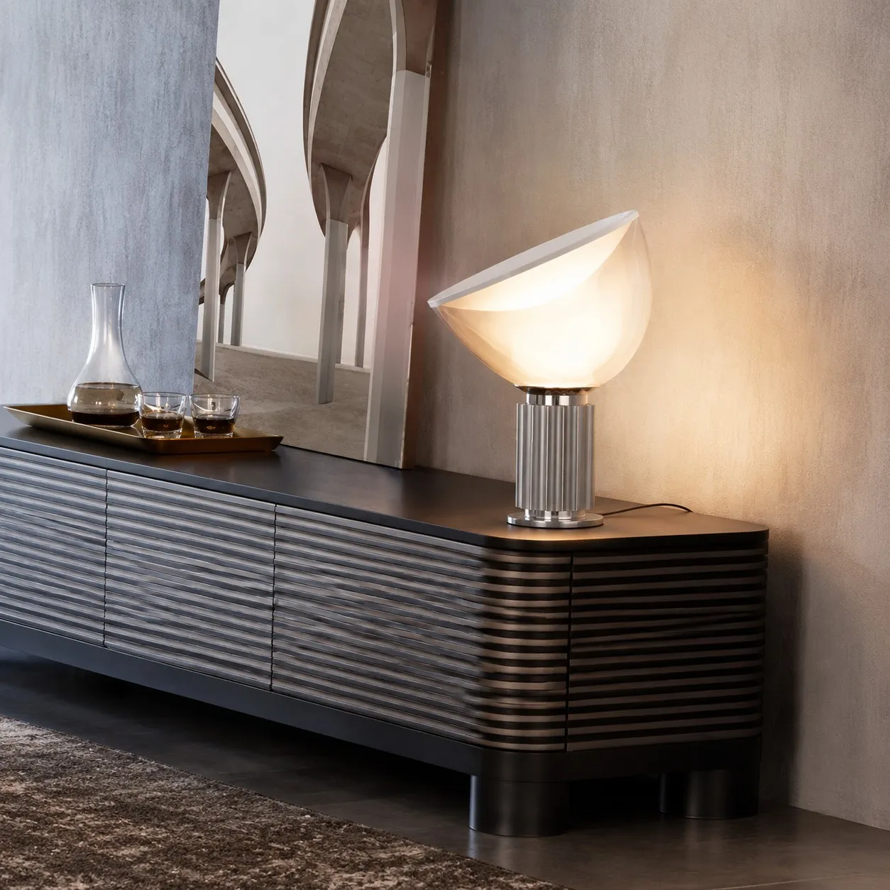 Silver Taccia lamp glowing on a sideboard