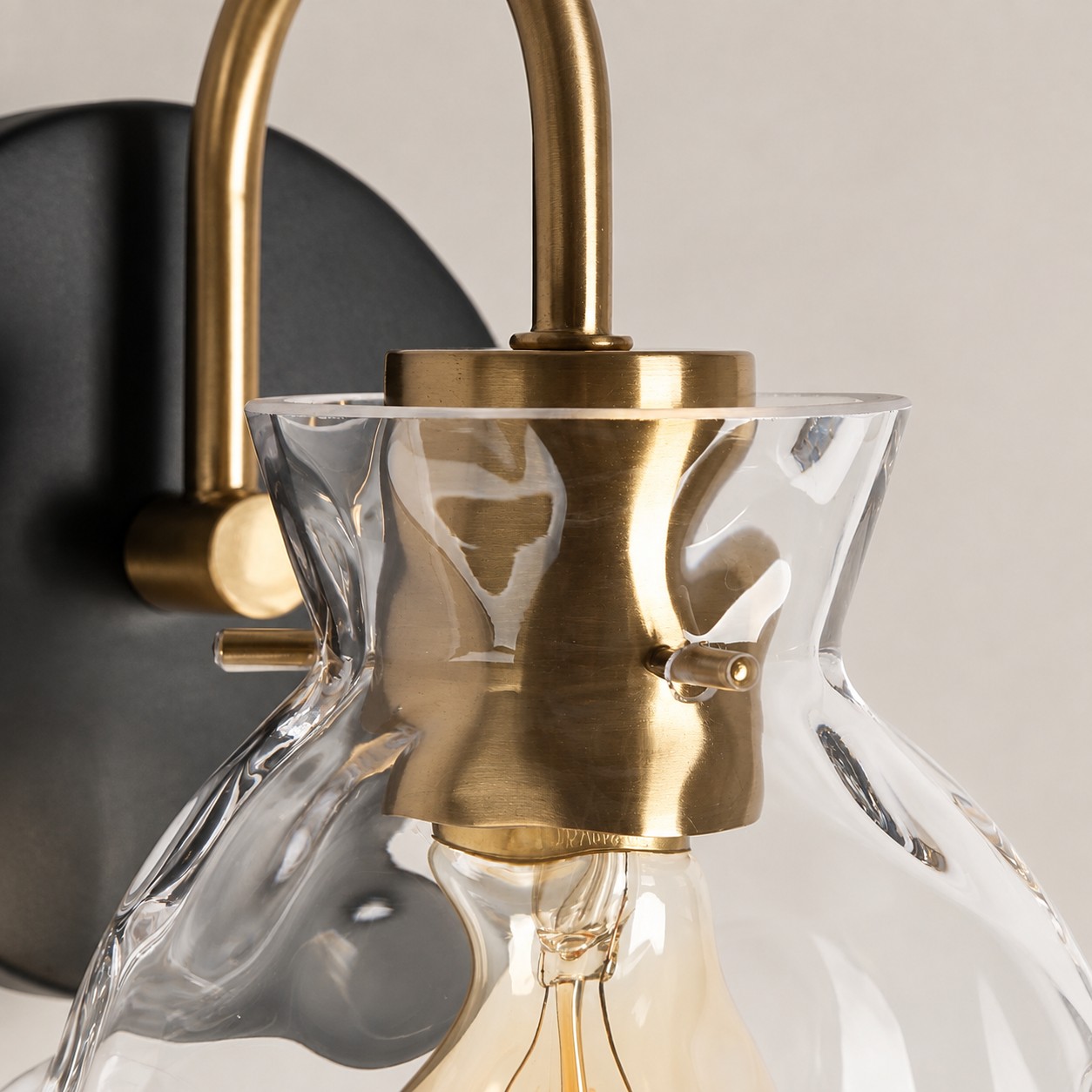 Textured Glass Wall Sconce with a clear shade and a curved arm