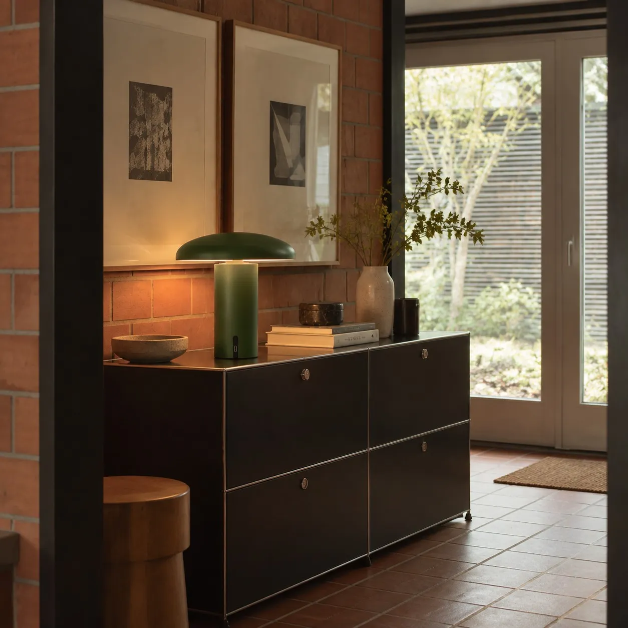 Green Takku portable table lamp on an interior sideboard