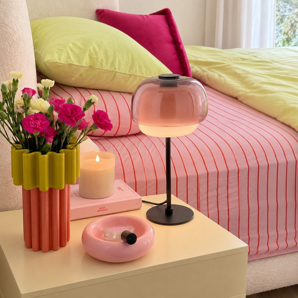 Blush double-dome glass table lamp on a bedside table
