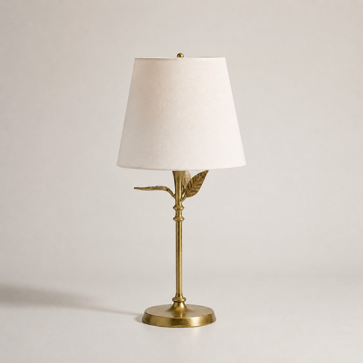 Antique brass botanical table lamp with a white linen shade