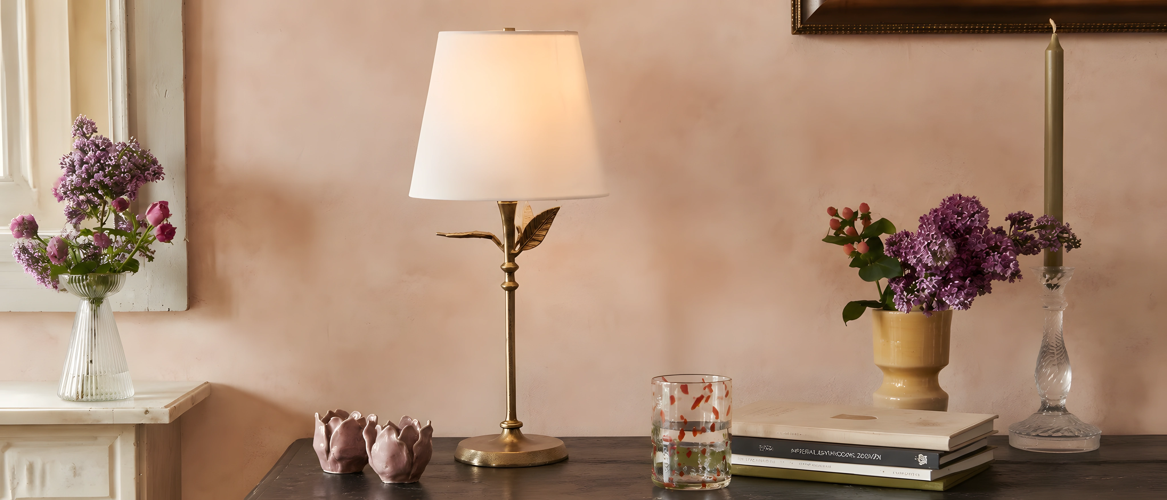 Antique brass botanical table lamp with a white linen shade on a console