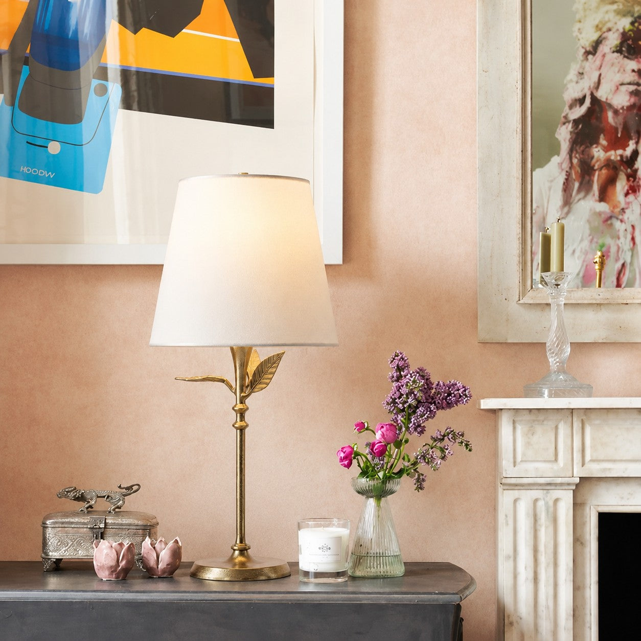Botanical table lamp on a charcoal console by a mantel