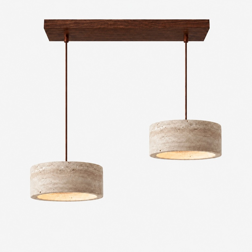 Two large cream travertine drum pendants on a walnut bar