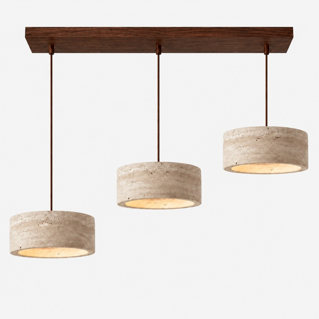 Three large cream travertine drum pendants on a walnut bar