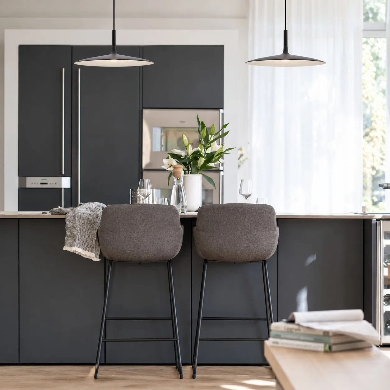 Black disc pendant lights above a kitchen island